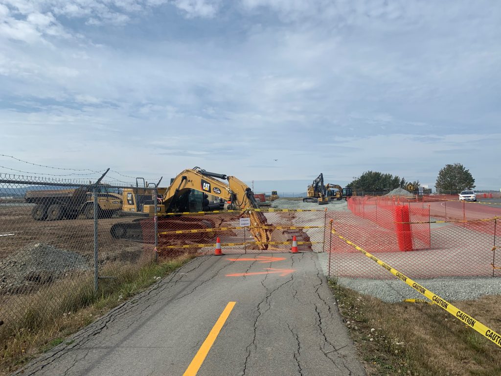 Flight Path under construction near roundabout. Backhoe operating with construction fencing.